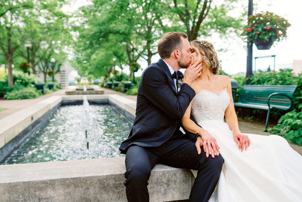 bride and groom kissing by fountain in dayton ohio 