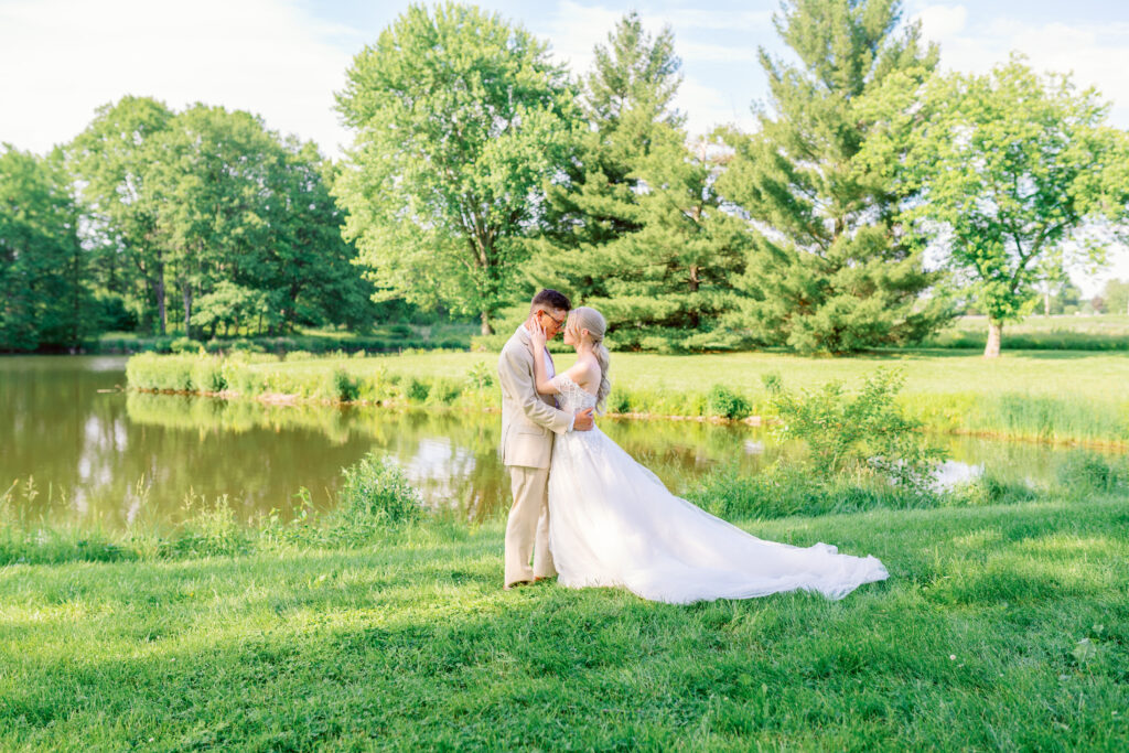 bride and groom cuddling infront of a lake a historic white oak