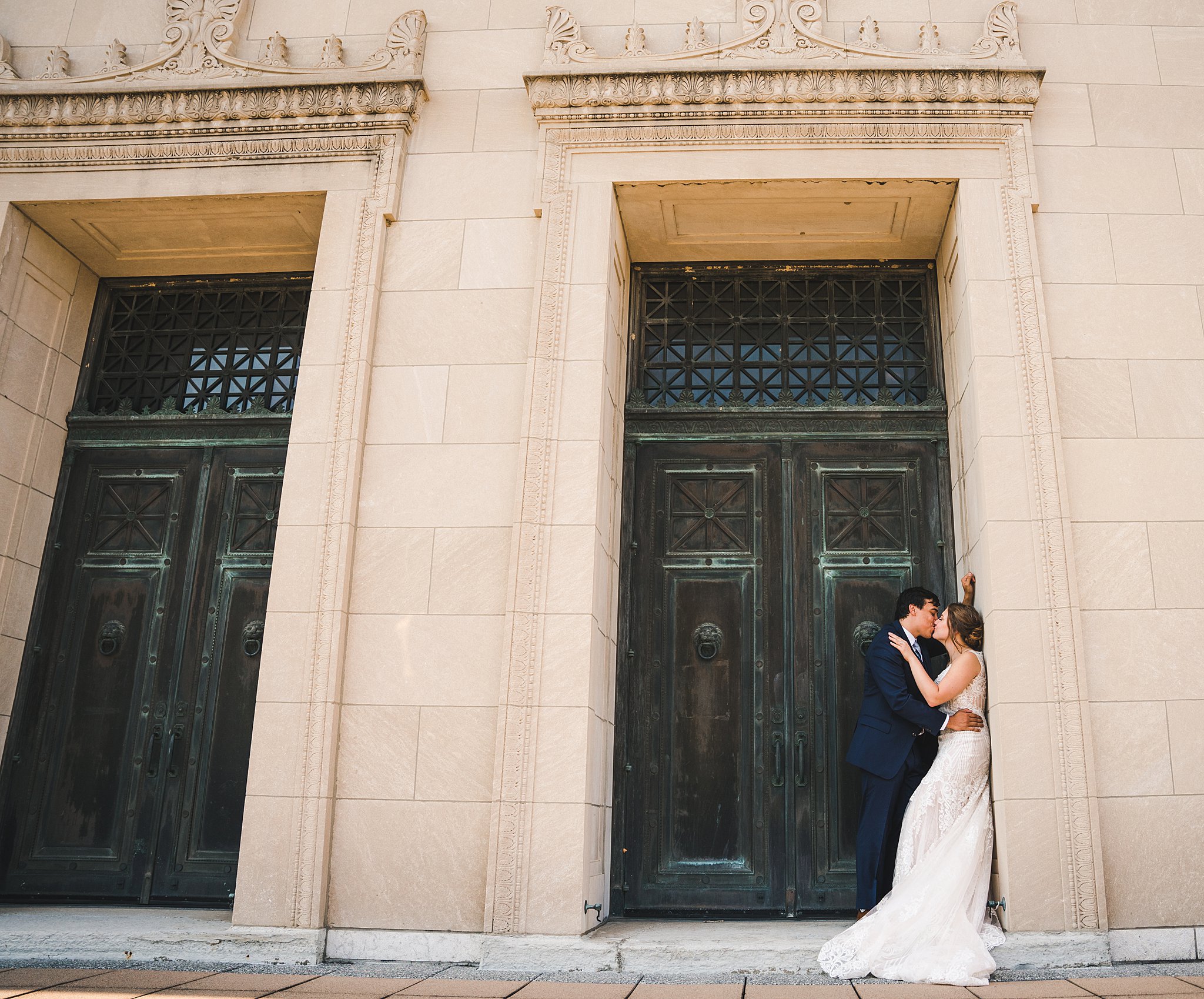 Newlyweds kiss in a large doorway of an ornate stone building unique wedding venues dayton ohio
