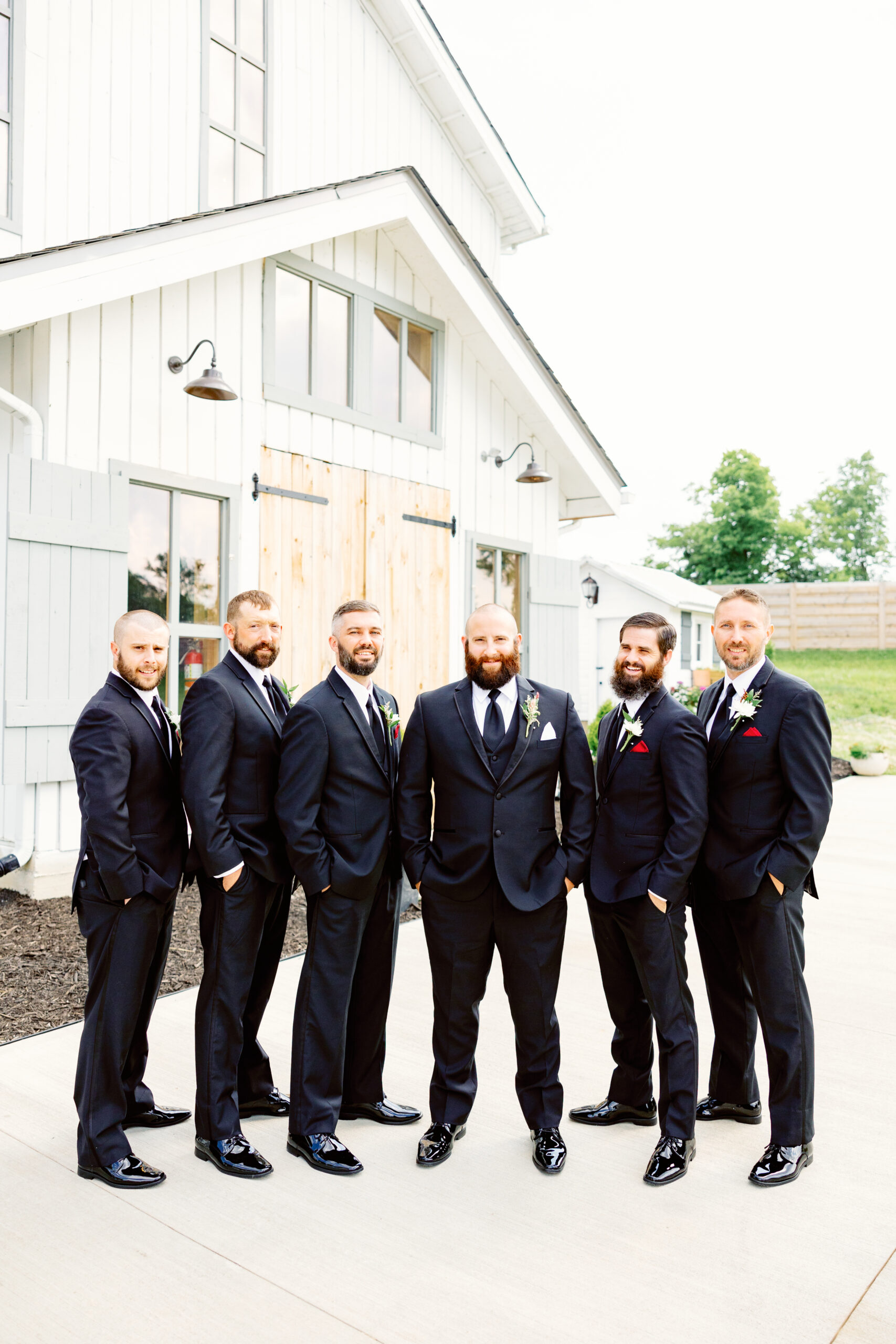 The groomsmen posing in front of the barn.